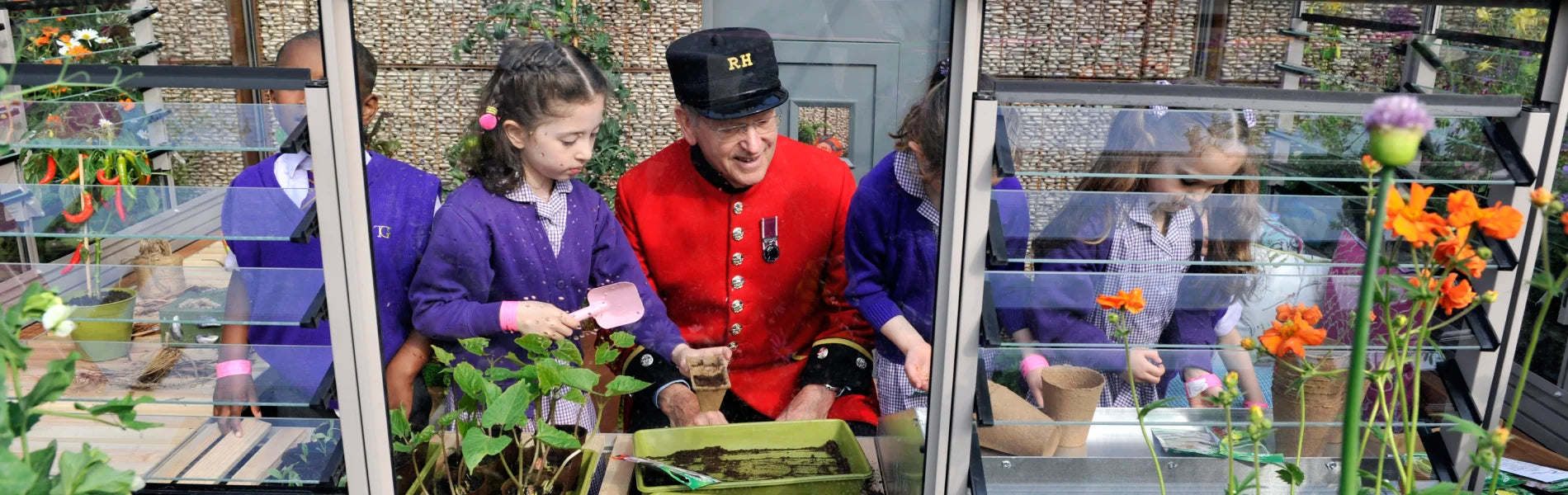 Young children gardening in a greenhouse