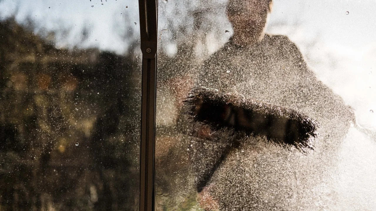 Man cleaning his greenhouse glass