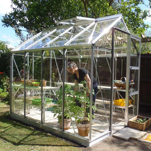 Woman moving plants into her Rhino Greenhouse