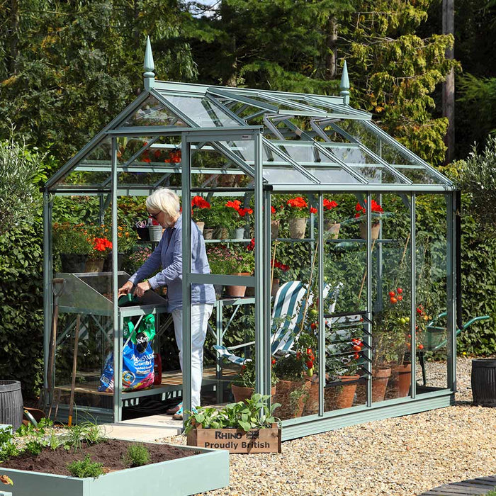 Lady potting plants inside her Rhino Premium Greenhouse